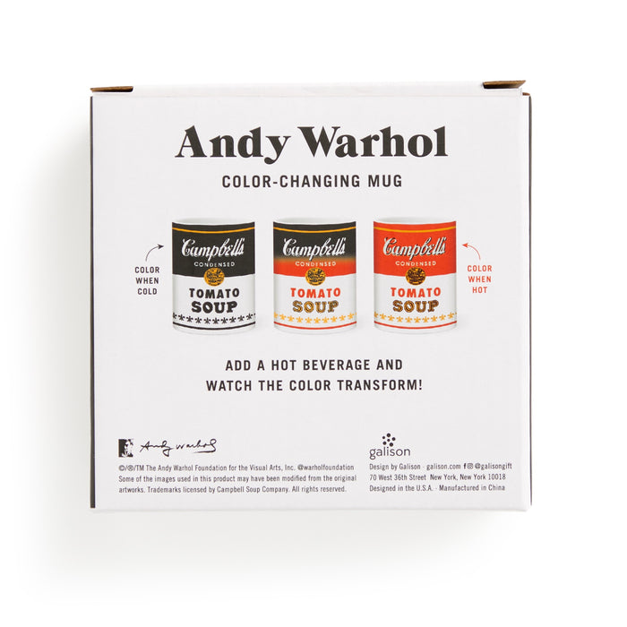A white box showcases the Andy Warhol Soup Can Color Changing Ceramic Mug. Three mugs shift from black-and-white when cold to red-and-yellow when hot. Instructions describe the brand’s signature color-changing effect.