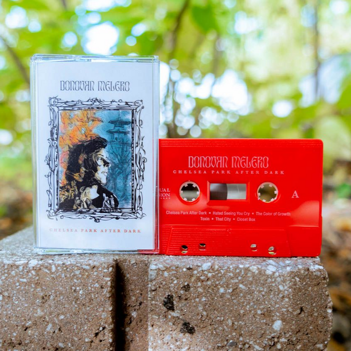 White cassette case with a drawing of a picture frame in the middle. Inside the frame, there is a person looking to the side. Inside the frame, the background colors are half yellow and half blue. On the side of the case and above the frame, there is text that says DONOVAN MELERO. Below the frame, there is small text that says CHELSEA PARK AFTER DARK. In front of the case there is a red cassette with DONOVAN MELERO written on top, and below it there is text that says CHELSEA PARK AFTER DARK.
