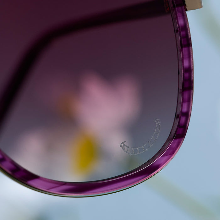 still life - diff eyewear x disney alice in wonderland cheshire cate oversized navigator sunglasses detailed view of lense with etched cheshire cat smile