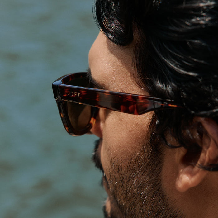lifestyle - male wearing diff eyewear mercer square sunglasses with a rich tortoise acetate frame and g15 polarized lenses detailed view of temples