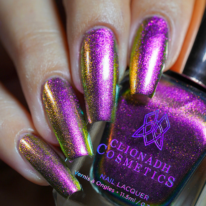 Close up shot of nails done with Smoulder Lite nail lacquer on fair skin tone holding the nail lacquer bottle