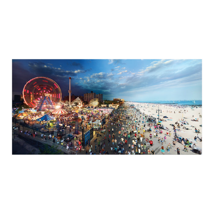 The Stephen Wilkes Day To Night Coney Island 1500 Piece Puzzle features a vibrant sunset scene with a bustling beach and an illuminated amusement park, with the sky shifting seamlessly from day to night.