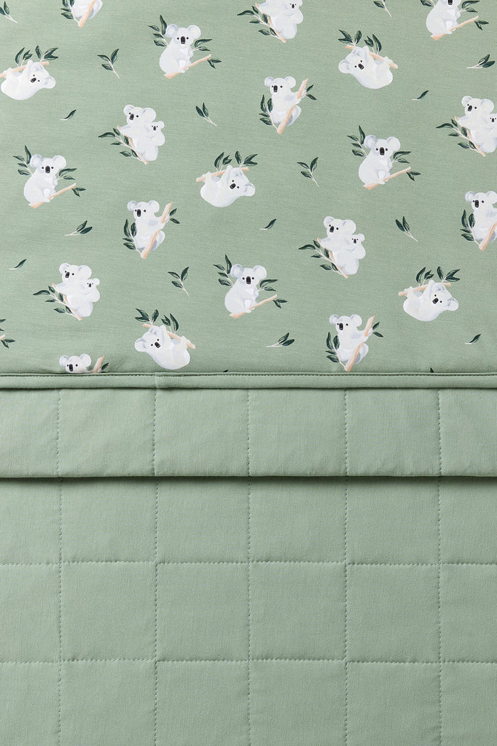 Close up of the Toddler Blanket in Koala 1.0 showing the quilted green backing and smooth top printed layer