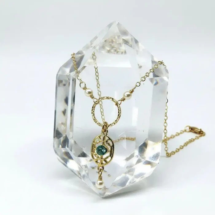 14 K Gold-Filled Hammered Open Circle Filigree Necklace displayed on a crystal quartz, featuring intricate design and elegance.
