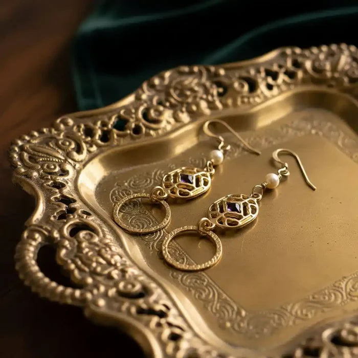 14 K Gold Filled Purple Crystal Circle Filigree Earrings displayed on an ornate gold tray.