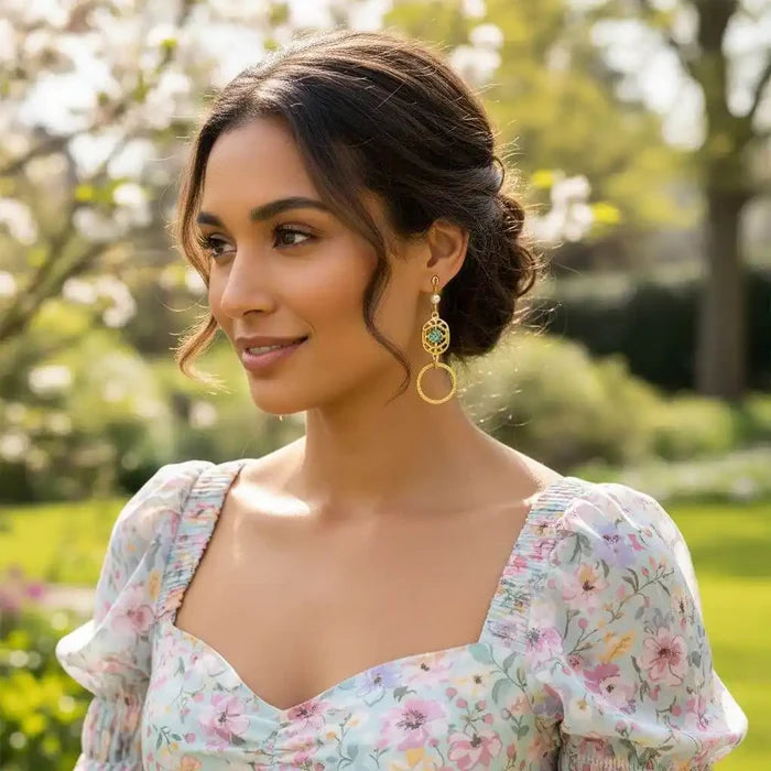 Model wearing 14 KT Gold Filled Green Crystal Circle Filigree Earrings in a floral dress outdoors.