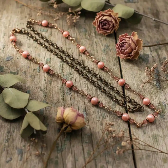 24-Inch Copper Peach Pearl Crystal Wire Wrapped Necklace displayed with dried flowers on a rustic wooden surface.