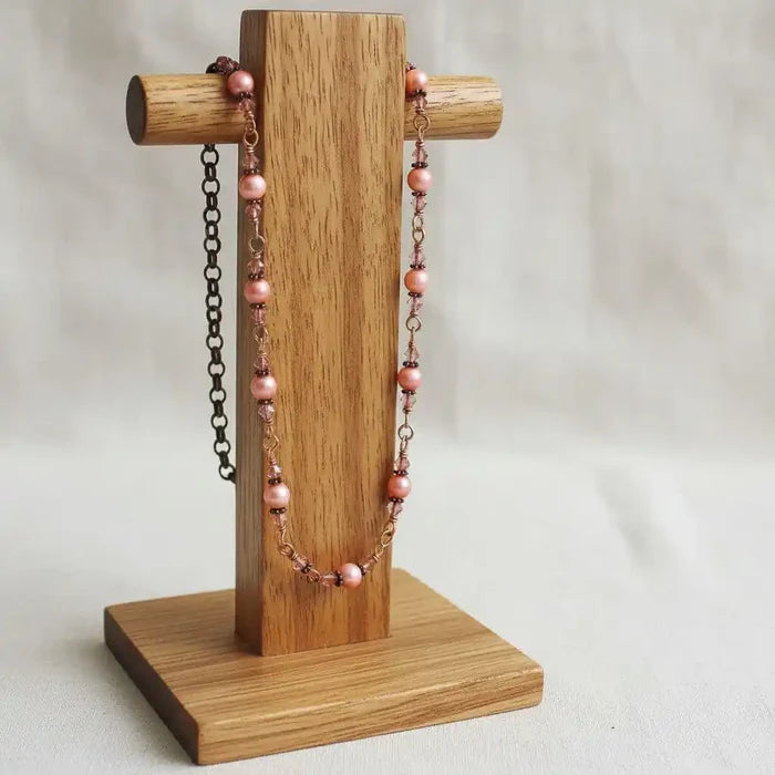 24-Inch Copper Peach Pearl Crystal Wire Wrapped Necklace displayed on a wooden jewelry stand.