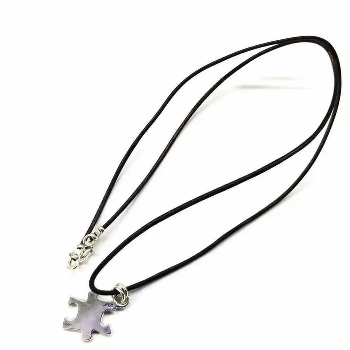925 Silver Autism Awareness Puzzle Piece Leather Necklace on a black cord, featuring a silver puzzle piece pendant.