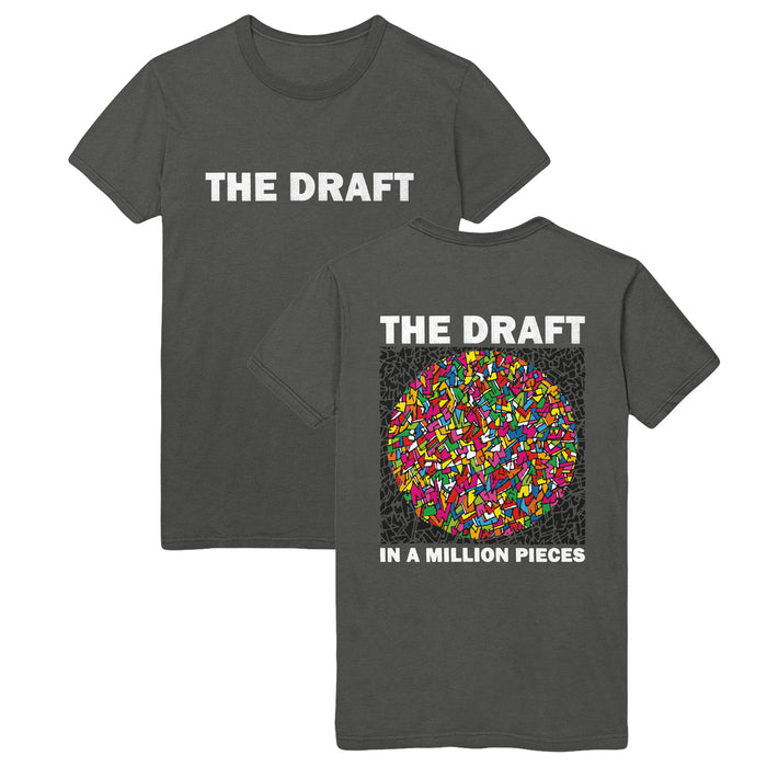 Charcoal gray t-shirt with words "THE DRAFT" printed in bold white towards top center of shirt. Back of shirt says "THE DRAFT". Below is a drawing of a circle with several small shapes in different colors (yellow, pink, orange, blue, green). Below the drawing reads "IN A MILLION PIECES".