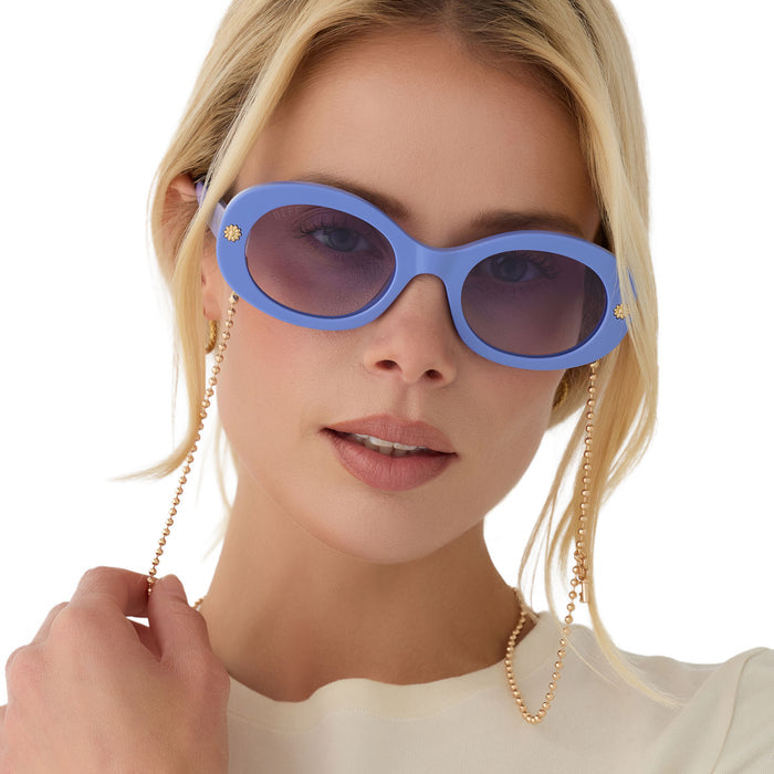 on model - female wearing diff eyewear x disney alice in wonderland alice round sunglasses in a periwinkle blue acetate frame and periwinkle blue gradient lenses front with golden chain