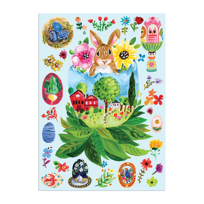 Celebrate Easter with the Artisanal Eggs Greeting Card Puzzle by Jennifer O Lewis / August Wren, featuring a bunny peeking from a cracked egg, spring landscape, flowers, decorative eggs, and nesting dolls on a light blue background.