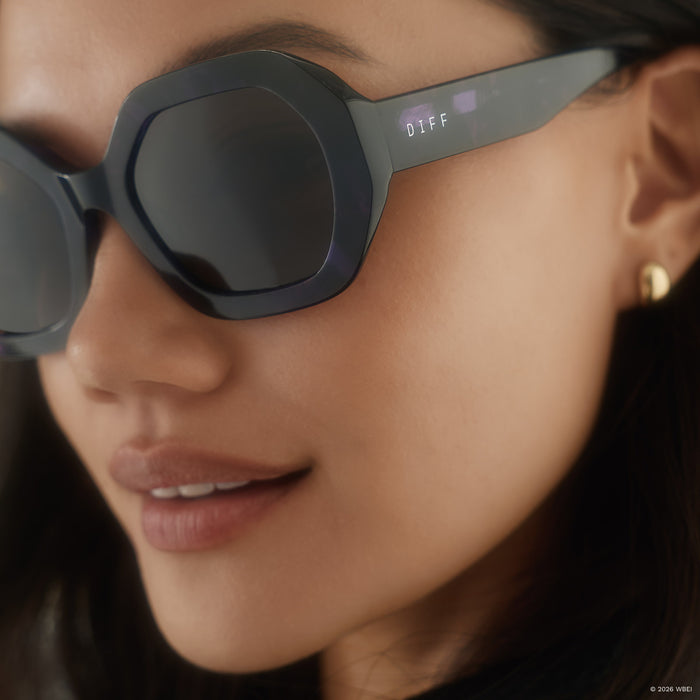 on model - female wearing diff eyewear x practical magic 2 aunt jet round sunglasses with a purple tortoise frame and brown lenses detailed view