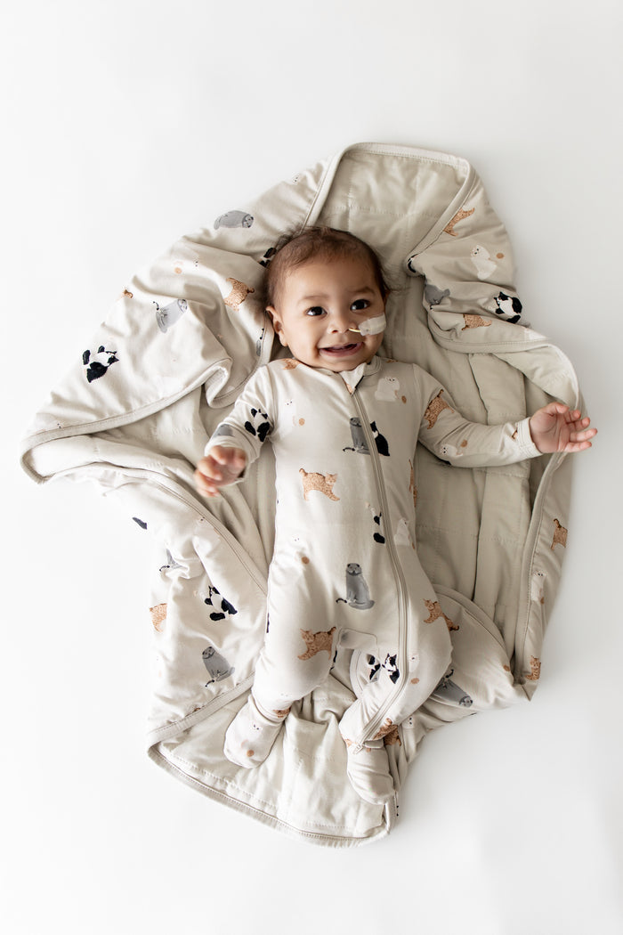 Smiling infant laying on a Baby Blanket in Fluffy Cat wearing a matching zippered footie