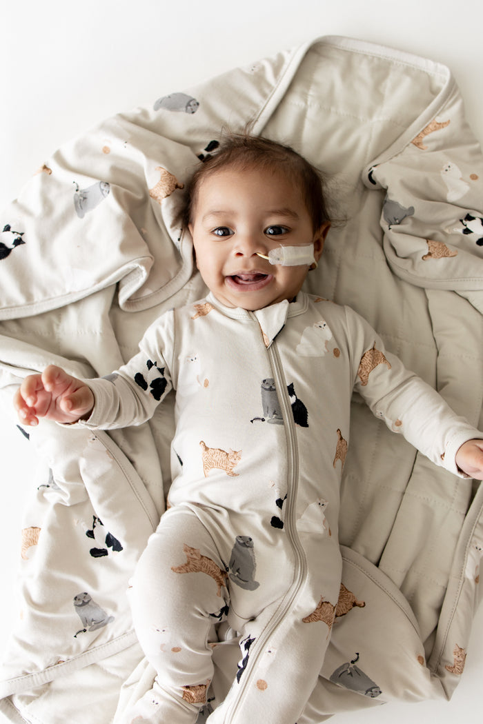 Close up of infant laying on a Baby Blanket in Fluffy Cat wearing a matching zippered footie