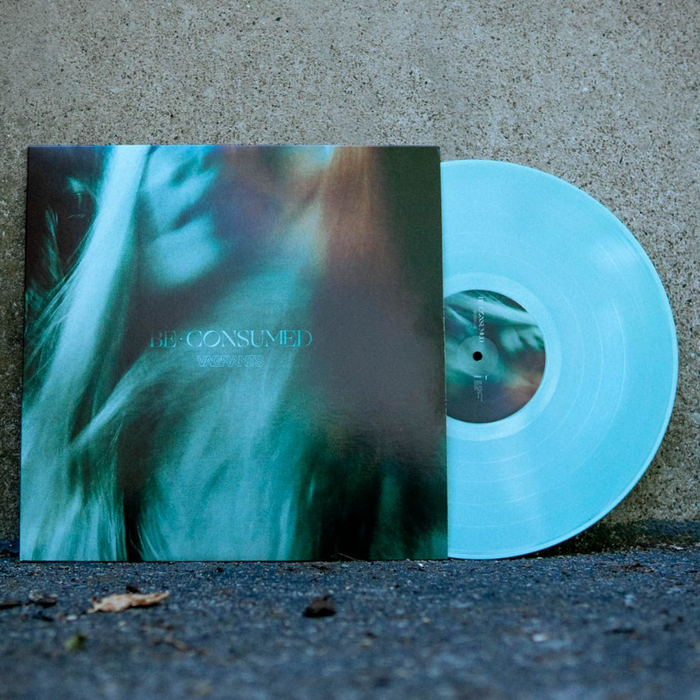 Vinyl jacket with an up close photo of a ghastly looking woman. The vinyl is mint green colored, as well as the disc peeking out of the right side of the jacket. The center of the jacket says BE CONSUMED.