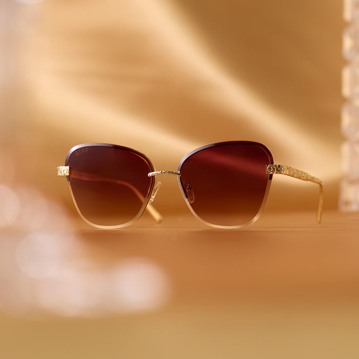 still life - diff eyewear x disney princess featuring the belle 3.0 cateye sunglasses with a metal gold frame and brown gradient lenses angled view