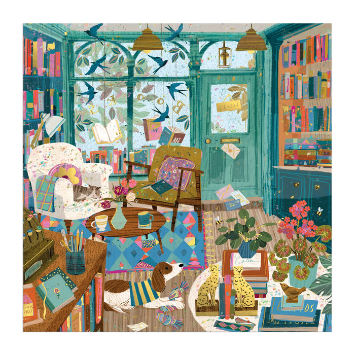The Bookshop Afternoon 500 Piece Foil Puzzle by Victoria Ball features a cozy, colorful room with books, plants, a dog on a rug, and sunlight streaming through large windows—an inviting scene perfect for literary lovers.