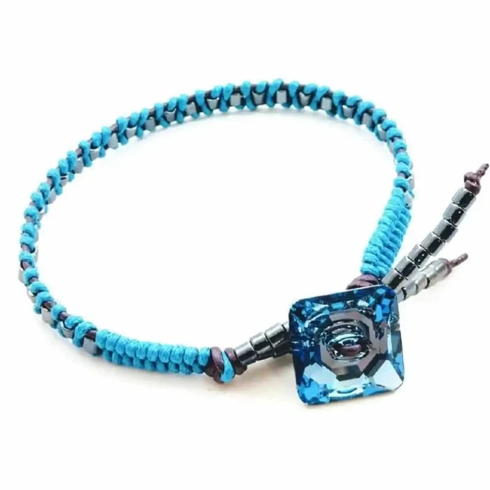Aqua Hematite Bead Braided Swarovski Crystal Button Bracelet showcasing turquoise beads and a square blue crystal centerpiece.