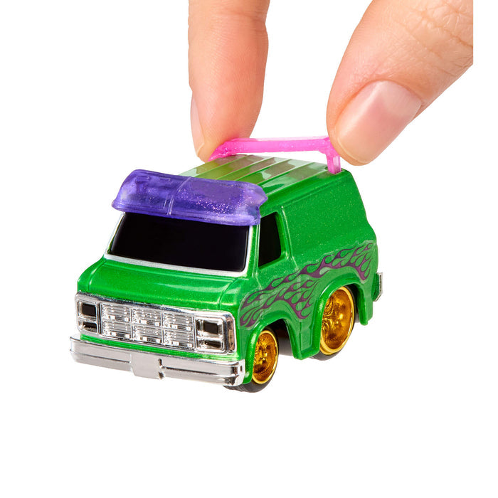Small green toy van with purple roof  visor and gold wheels held by a hand on a white background