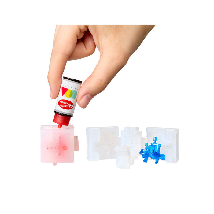 Hand holding a small cartridge with colorful design, on a white background