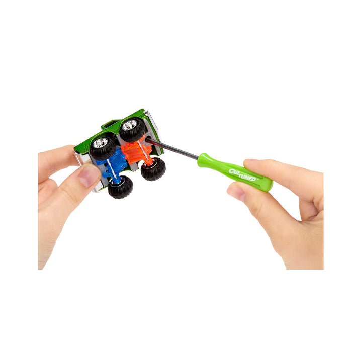 Person using a green screwdriver to connect the trucks top and bottom on a white background