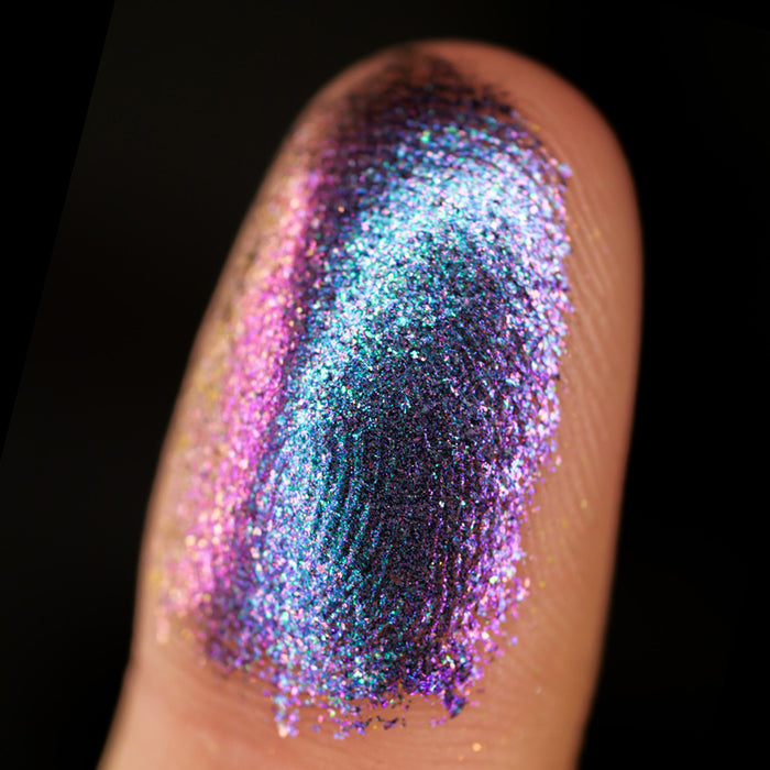Macro finger swatch of Catalyst Dimensional Multichrome Eyeshadow on fair skin tone.
