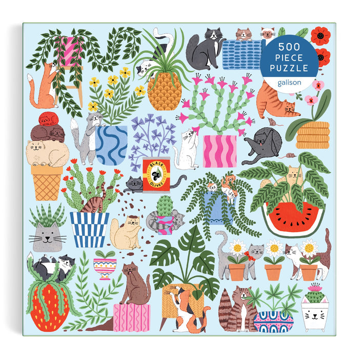The Holly Maguire Cats in the Houseplants 500 Piece Puzzle features playful cat illustrations among houseplants and fruits on a light blue box, with 500 Piece Puzzle labeled in the top right corner.