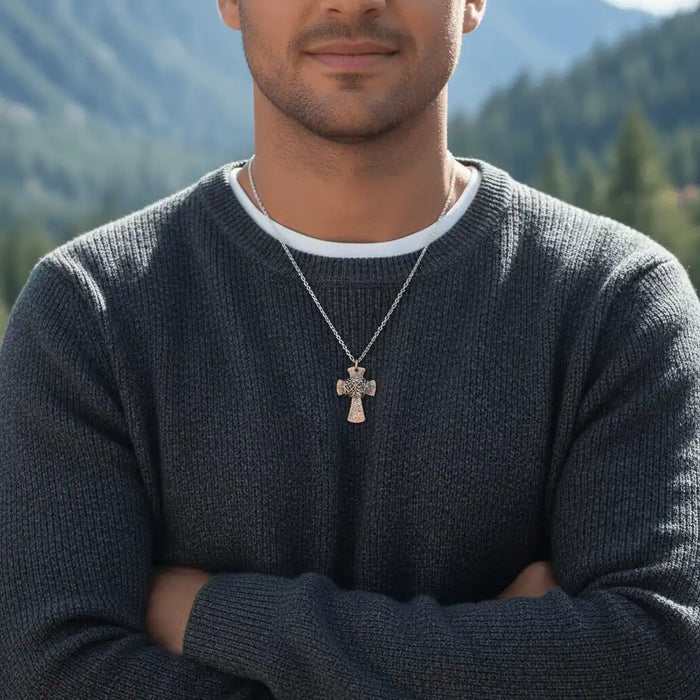 Chained Hammered Copper Cross Necklace For Him Or Her worn by a man outdoors with mountains in the background.
