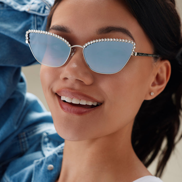 lifestyle - female wearing diff eyewear x disney princess featuring the cinderella 2.0 cateye sunglasses with a silver metal frame and grey gradient silver flash lenses front view