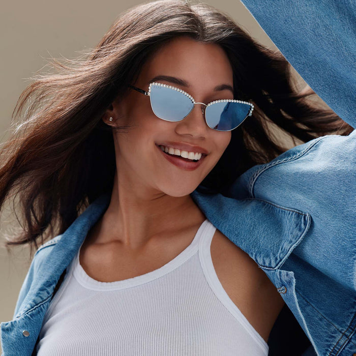 lifestyle - female wearing diff eyewear x disney princess featuring the cinderella 2.0 cateye sunglasses with a silver metal frame and grey gradient silver flash lenses angled view