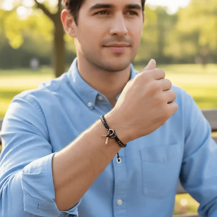 Copper Ribbon Black Pink Braided Breast Cancer Bracelet worn by a man outdoors, symbolizing support and strength.