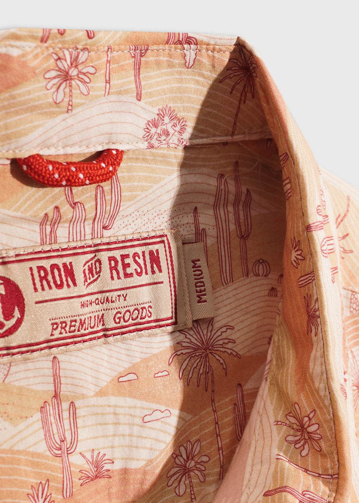 Shirt collar with desert-themed print, featuring cacti and palm trees. Label reads "Iron and Resin, High-Quality Premium Goods."