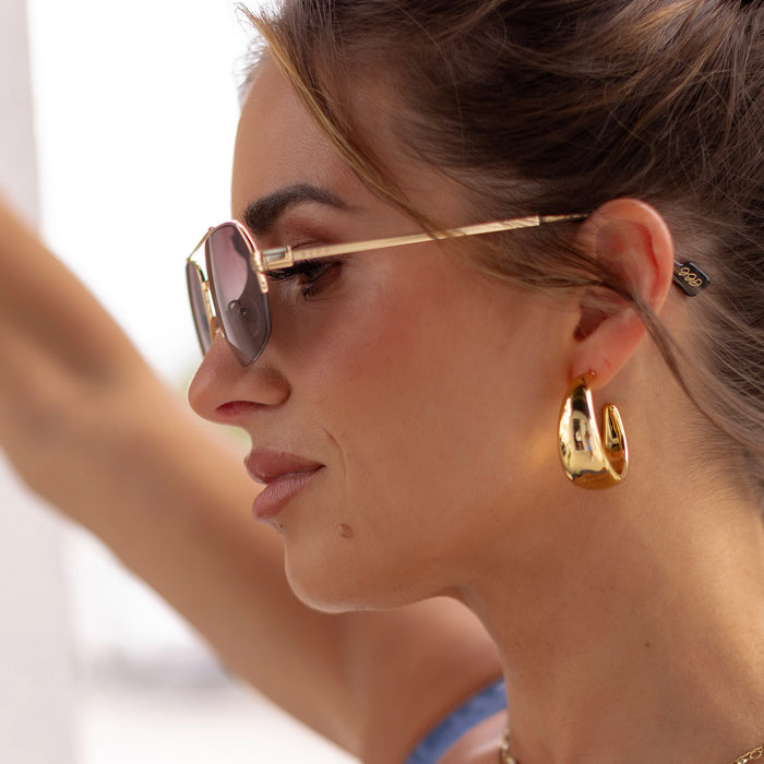 lifestyle - female wearing diff eyewear x jessie james decker destiny navigator sunglasses with a gold metal frame and brown gradient lenses side view
