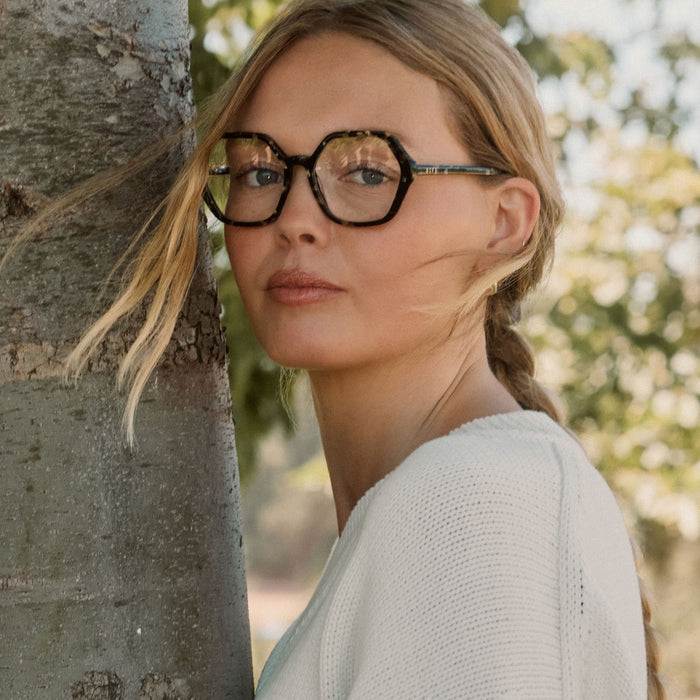 lifestyle - blonde female wearing diff eyewear featuring the dixie hexagon prescription glasses with a espresso tortoise frame and prescription lenses angled view