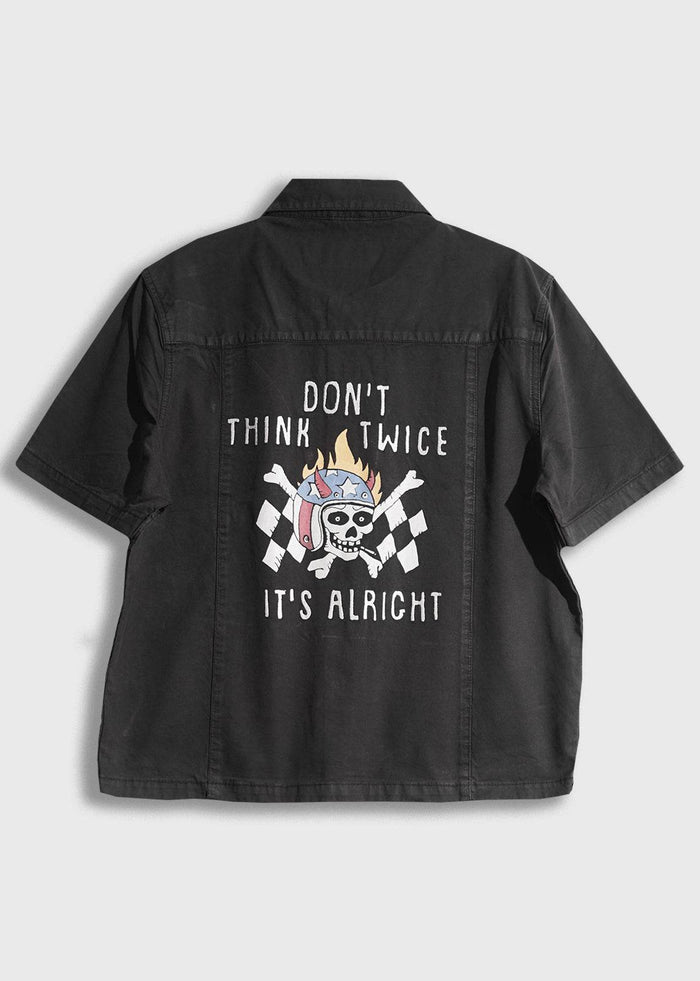 Black shirt with a skull and checkered flags, text reads "Don't think twice, it's alright" in white. Casual, edgy design.