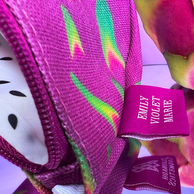 Close up "Emily Violet Marie" on one side of tag and "Clionadh Cosmetics" on other side on The Dragon Fruit Cosmetics Bag