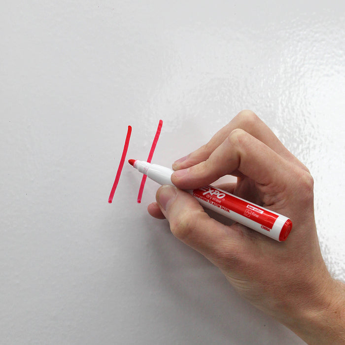 A red dry erase marker drawing lines on the dry erase wallpaper from Tempaper.