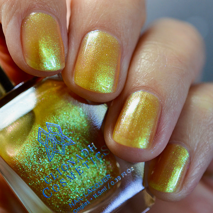 Embellishment nail lacquer on 4 finger nails, holding a nail polish bottle