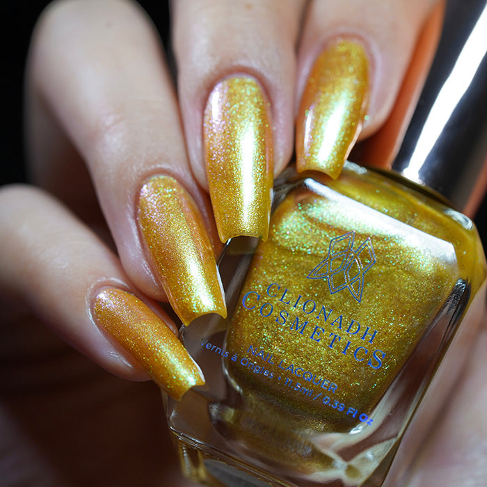 Close up shot of nails done with Embellishment nail lacquer on fair skin tone holding the nail lacquer bottle