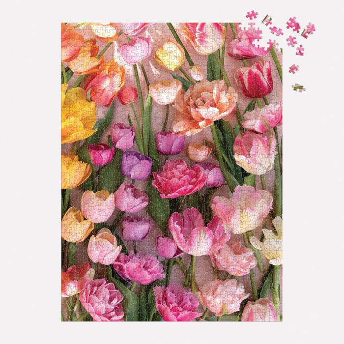 The Ephemeral Tulips 1000 Piece Puzzle by Christine Chitnis features a vibrant bouquet in pink, purple, and yellow. A few pieces are still missing and scattered at the top right corner.