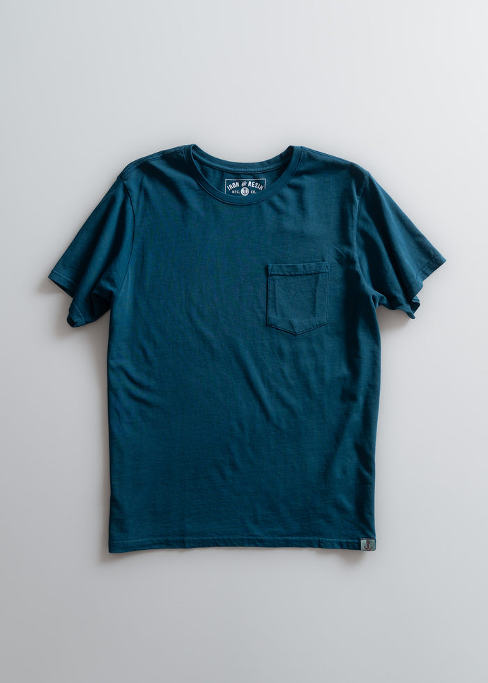 Blue t-shirt with a chest pocket, displayed on a plain background. The label reads "Iron & Resin." Simple and classic design.