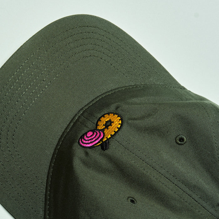 Green cap with a colorful embroidered design on a light gray background