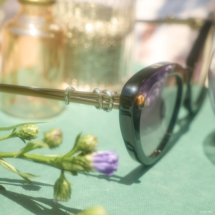 still life - diff eyewear x practical magic 2 gillian cateye sunglasses detailed view laying on a book outdoors