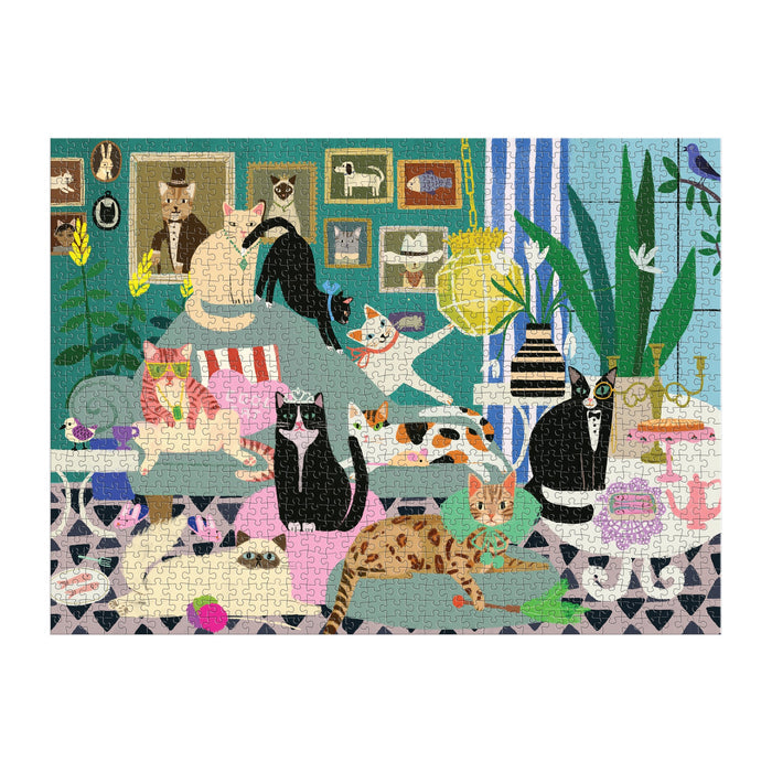 Anne Bentley’s Glamour Cats 1000 Piece Puzzle features a vibrant living room scene with stylish cats lounging, playing, and exploring among plants, artwork, and eclectic decor—an ideal challenge for puzzle lovers.