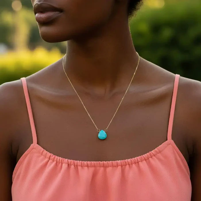 Gold Filled Aqua Jade Wire Wrap Gemstone Drop Necklace worn by a model in a pink dress outdoors.