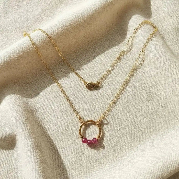 Gold Filled Pink Chalcedony Open Circle Necklace featuring a hand-hammered gold pendant and pink gemstones.