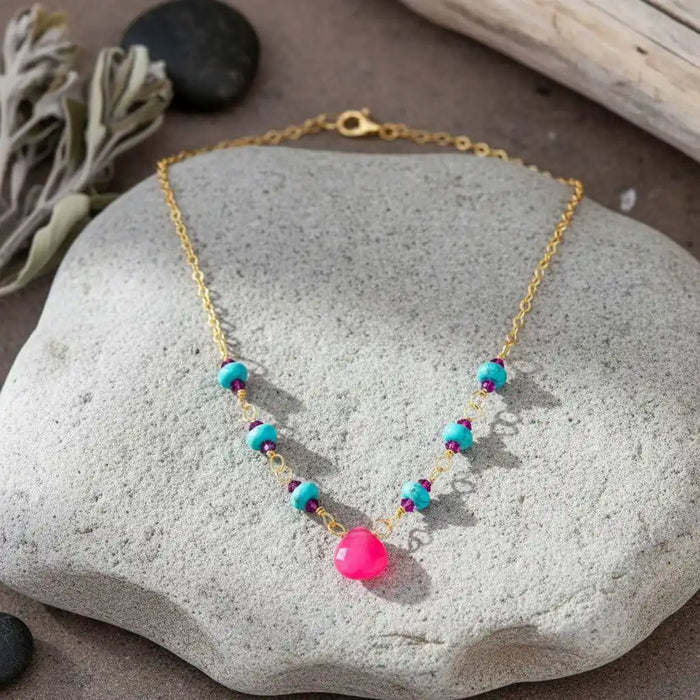 Gold Filled Pink Chalcedony Turquoise Gemstone Drop Necklace displayed on a stone surface, showcasing vibrant colors.