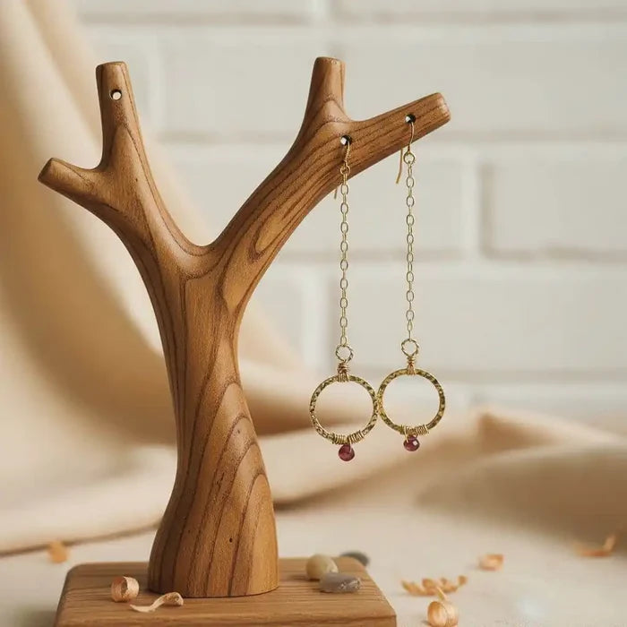 Gold Filled Wrapped Pink Chalcedony Open Circle Earrings displayed on a wooden tree stand, showcasing modern geometric design.