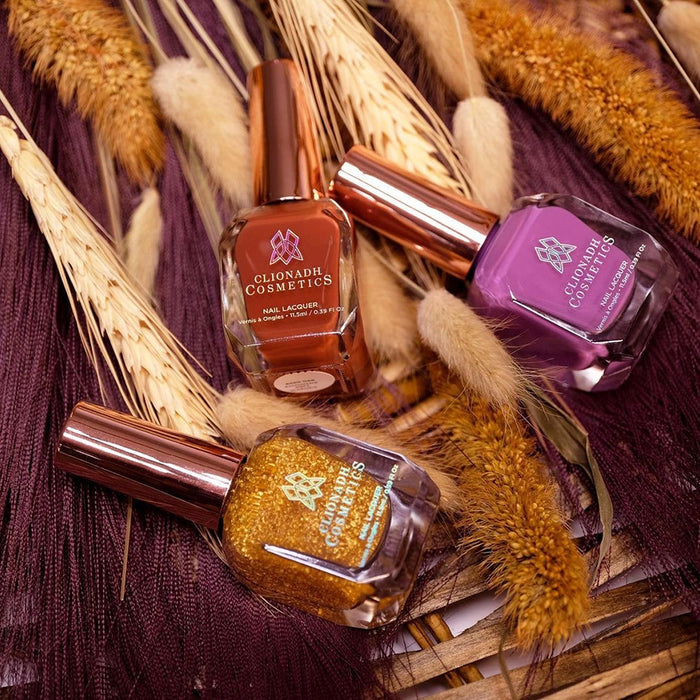 Top angled shot of the Anniversary Trio Nail Lacquer bottles laying on top of pampas and other weeds.